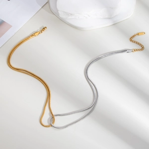 Detail of mixed gold and silver dual-tone snake bone chain necklace in stainless steel