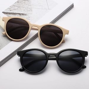 Occhiali da sole retrò con montatura rotonda in nero e beige per un look vintage elegante