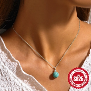 S925 sterling silver necklace with a round turquoise pendant on female collarbone