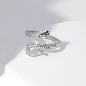 Macro shot of silver snake ring featuring detailed scales and adjustable open band design