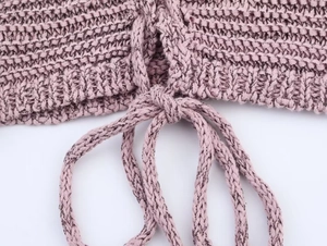 Detail of dusty pink knit texture showing thick yarn weave and drawstring cord design