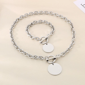 Detail of silver stainless steel necklace and bracelet set with toggle clasp and round pendant