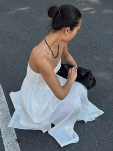 White cotton strapless maxi dress with smocked bodice and pleated skirt in street style