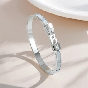 Close-up detail of silver titanium steel bangle with white shell inlay and rhinestones