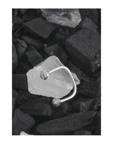 Close-up of S925 sterling silver open ring with double beads on white stone and charcoal