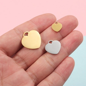 Polished heart pendants in gold and silver finish, different sizes on a soft background