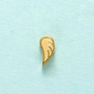 Macro view of a gold angel wing pendant charm for jewelry making on light blue background