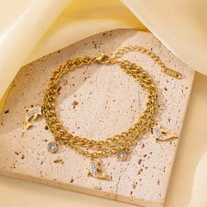 Primer plano de la pulsera de doble capa dorada con dije de delfín y grabado K18