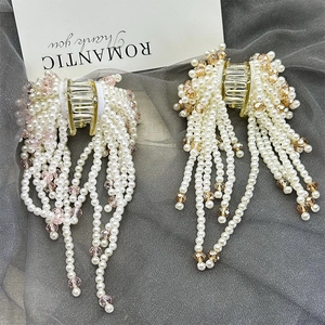 Elegant pearl and crystal tassel hair claw clip with pink beads on dark mesh background