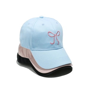Three-color stack of baseball caps in blue, pink, and black with bow embroidery