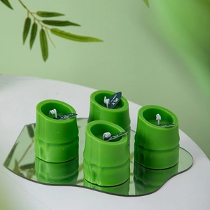 Bamboo shaped green scented candles set on a mirror tray with minimalist decor