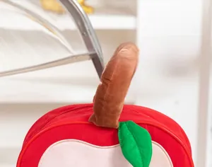 Front detail of red apple-shaped makeup bag with green leaf and plush brown handle