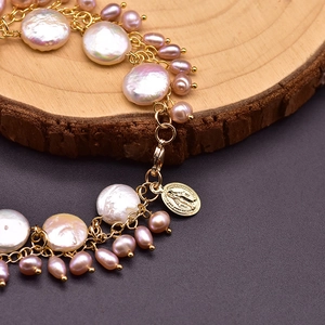 Handmade multi-layer baroque pearl bracelet with gold medallion charm on wood surface
