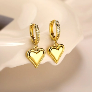 Macro shot of gold hoop earrings with heart charms and micro-pave cubic zirconia crystals