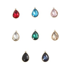 Macro view of teardrop birthstone pendants in gold frame with eight different crystal colors