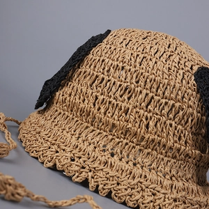 Detail shot of hand-woven straw bucket hat with cute black ears and crochet texture