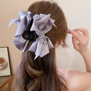 Detailed back view of a large light purple satin bow hair claw with a crystal center