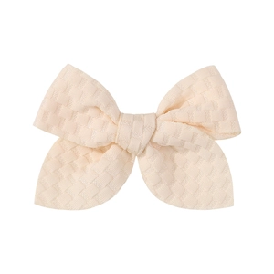 Macro view of textured jacquard fabric texture on a beige handmade 3.3-inch hair bow clip