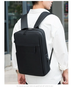 Detail of black minimalist backpack showing a side USB charging port for commuters