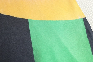 Vista macro della texture del tessuto liscio con motivi a blocchi di colore giallo e verde
