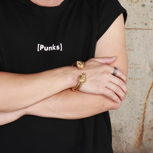 Detail of punk style lion head gold bracelet and silver ring set on a male model