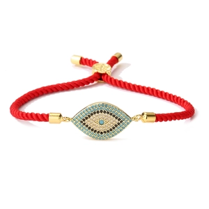 Detail of red string evil eye bracelet featuring micro-pave zircon in gold-plated frame