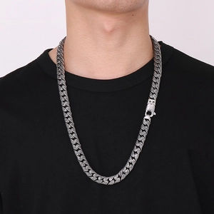 Detail of silver Cuban link necklace with square rhinestone clasp on model in black shirt