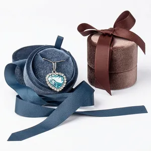 Elegant round velvet jewelry gift box with satin ribbon bow and crystal heart necklace