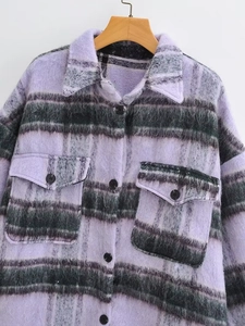 Detail of purple plaid fuzzy coat featuring a large lapel and double front pockets
