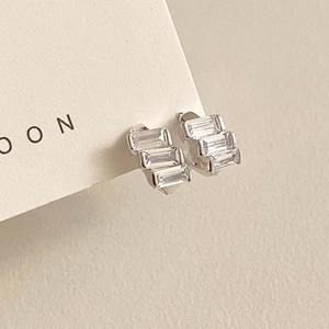 Macro shot of S925 silver stud earrings featuring tiered rectangular cubic zirconia stones