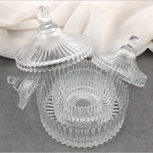 Detailed view of three vintage ribbed glass storage jars with dome lids and round handles