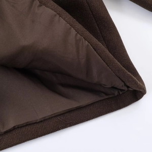 Detailed macro view of dark brown wool coat hem showing high-quality silky inner lining