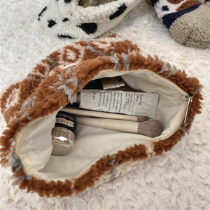 Detailed interior view of a large plush winter cosmetic bag filled with makeup and brushes
