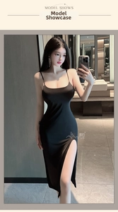 Close-up of a sexy black satin dress with a high side slit and slim fit silhouette