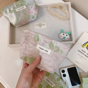 Macro detail of floral jacquard canvas mini pouch featuring simple wish label