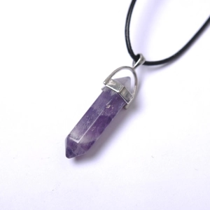 Detailed close-up of a purple amethyst hexagonal crystal point pendant with silver clasp