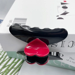 8.3cm black hair claw clip with red heart design on a minimalist white background