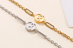 Detailaufnahme polierter Gold- und Silberarmbänder mit Unendlichkeitssymbol auf Beige
