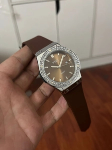 Macro view of crystal-encrusted bezel and textured brown rubber strap on women's watch