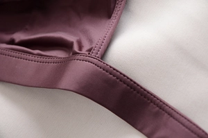 Dettaglio ravvicinato delle cuciture doppie e trama in maglia della lingerie viola senza ferretto