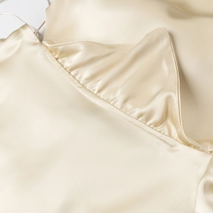 Detail of champagne satin dress showing premium fabric texture and elegant pleated stitching