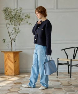 Chic female outfit with blue tweed cardigan, denim jeans, and a light blue tote bag