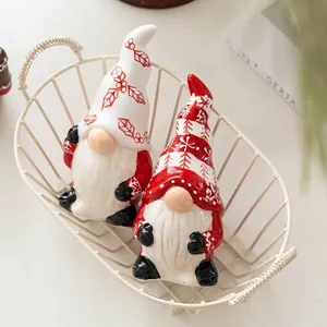 Christmas ceramic gnome figurines with holly and snowflake designs in a metal basket