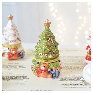 Detail of Christmas tree ceramic jewelry boxes with bear reliefs and cozy holiday lighting