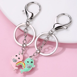 Cute cartoon narwhal magnetic couple keychains in pink and mint green with glitter heart