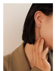 Close-up of a silver beaded ear cuff set in a minimalist style on a model's ear