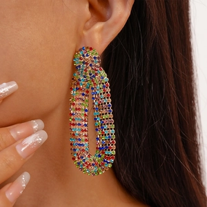 Close-up of model wearing colorful rhinestone pavé oval hoop earrings in luxury style