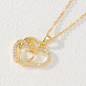 Close-up of gold double heart necklace with MOM lettering and zircon inlay details