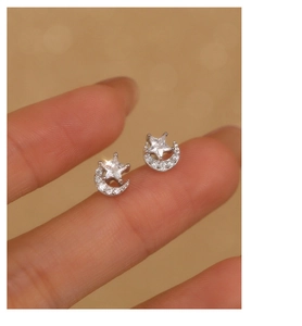 Macro shot of sparkling star and moon earrings with cubic zirconia on silver