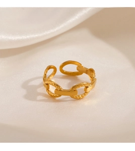 Detail of adjustable gold-plated chain style ring on soft beige silk background